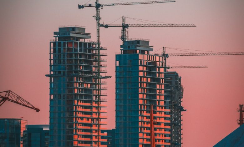 gray building crane photo during sunset