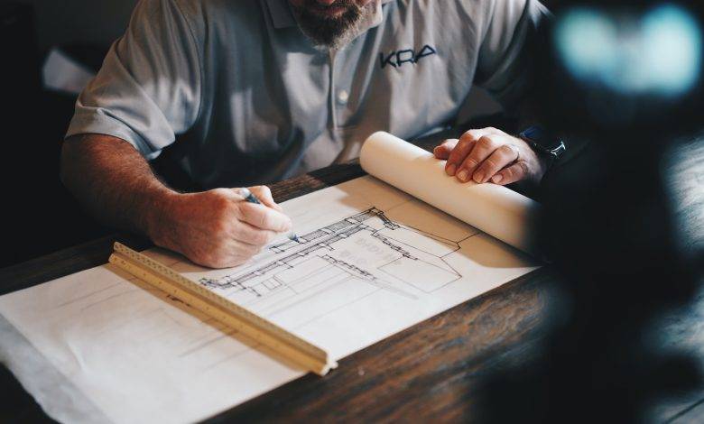 An architect working on a draft with a pencil and ruler