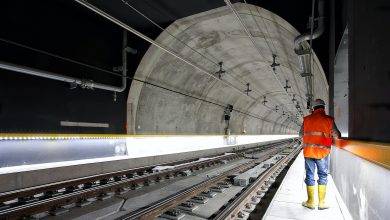 man standing beside train rail