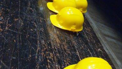 five yellow hard hats on gray surface