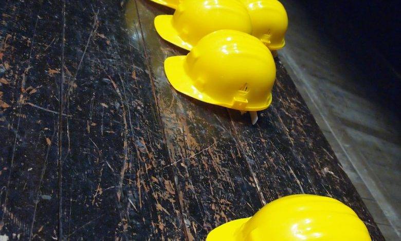 five yellow hard hats on gray surface